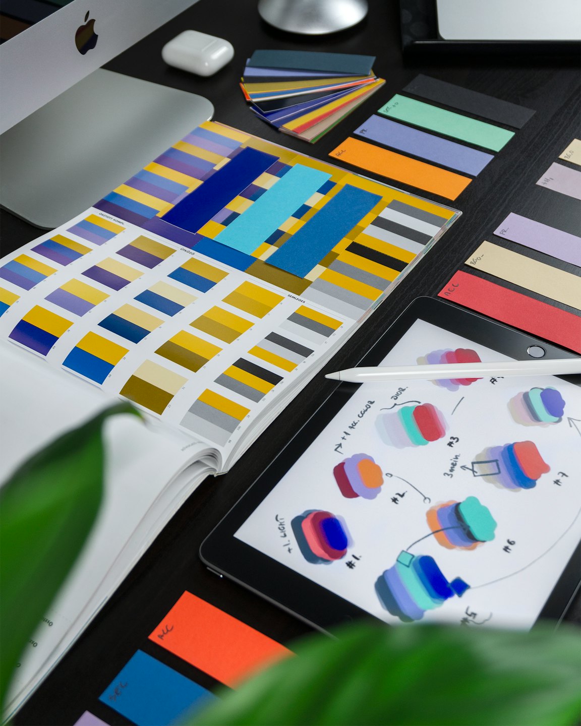 Biurko projektanta z próbkami kolorów, iPadem i Apple Pencil.